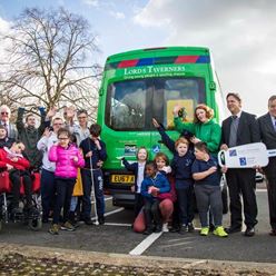 Group photo of all the children and stakholders posing infront of a green minibus