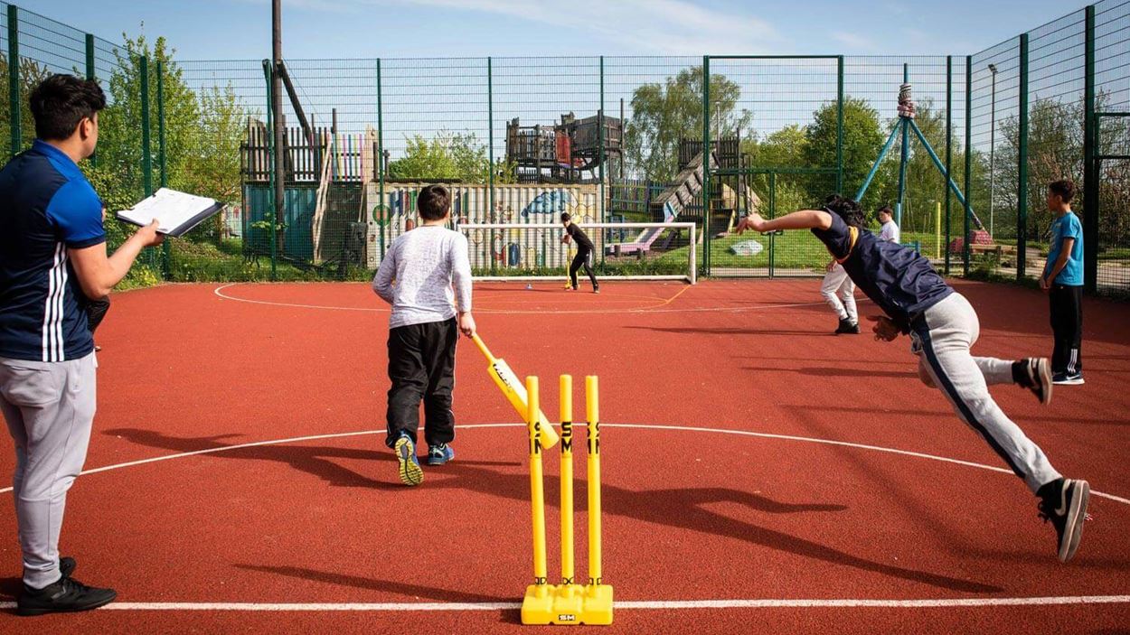 Boys sprinting after striking a ball